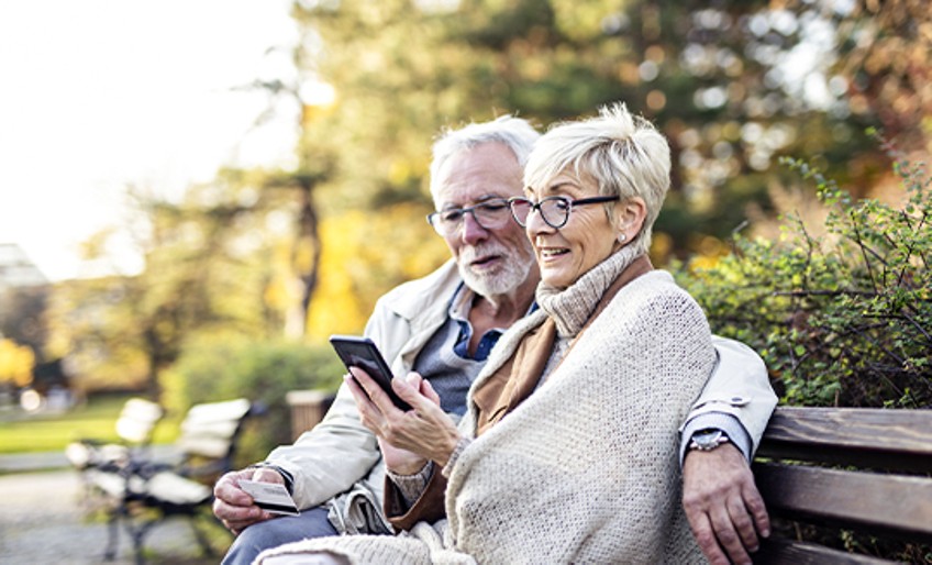 Sterbegeldversicherung: älteres Paar sitzt auf Parkbank
